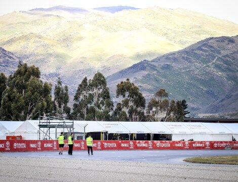 Calan Williams walking around the race track, mountains in the background